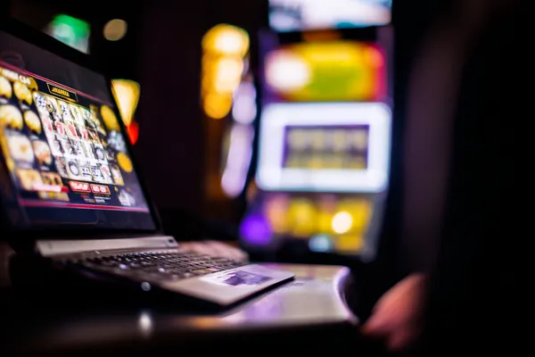 A woman smiling by bright slot machines showing lucky symbols, showcasing the exciting slot offerings at 6363PH.